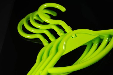 Siyah arkaplanda bir grup yeşil plastik askı