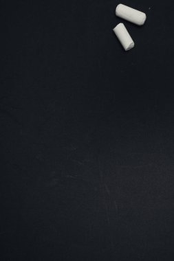Boş bir siyah yüzey üzerindeki iki beyaz tebeşir parçasının üst görüntüsü