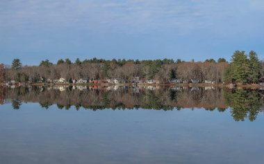 Evler ve ağaçlar sakin bir göle yansıdı.