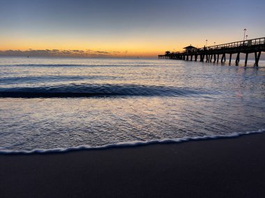 Florida 'nın doğu kıyısında bir balıkçı iskelesi ile Atlantik Okyanusu' nda gün doğumu