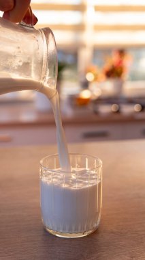 Bardağa süt dökmeye yakın çekim.