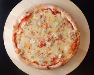 Domates soslu iştah açıcı bir pizza ve ahşap tepside peynirli mantar.