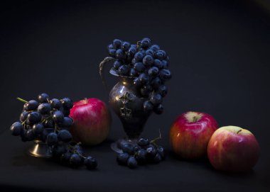 Siyah arka planda izole edilmiş elma ve siyah üzümlü sakin bir hayat.