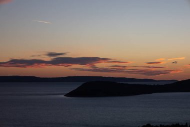 Huzurlu denizin üzerinde renkli günbatımının manzaralı bir görüntüsü