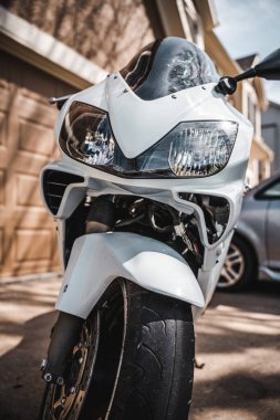 Kaldırıma park etmiş bir motosikletin dikey görüntüsü.