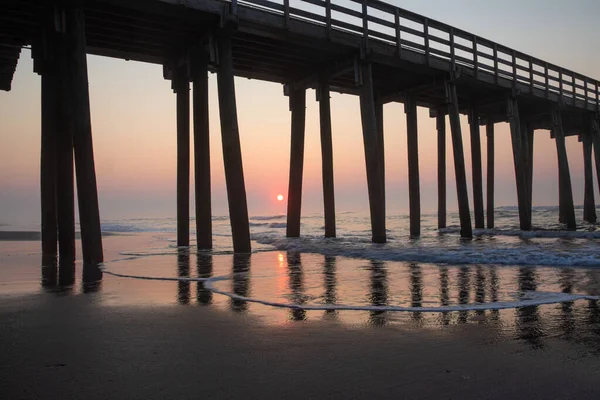 日の出に海岸にある大きな木製の桟橋 — ストック写真
