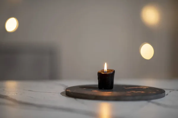 Een Voorgrond Shot Van Een Brandende Zwarte Kaars Een Witte — Stockfoto