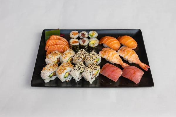 顶部的寿司设置在一个白色背景的黑色盘子上 — 图库照片