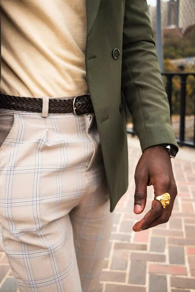 一个穿着绿色西装 米黄色衬衫和裤子 棕色腰带和金戒指的模特的垂直照片 — 图库照片