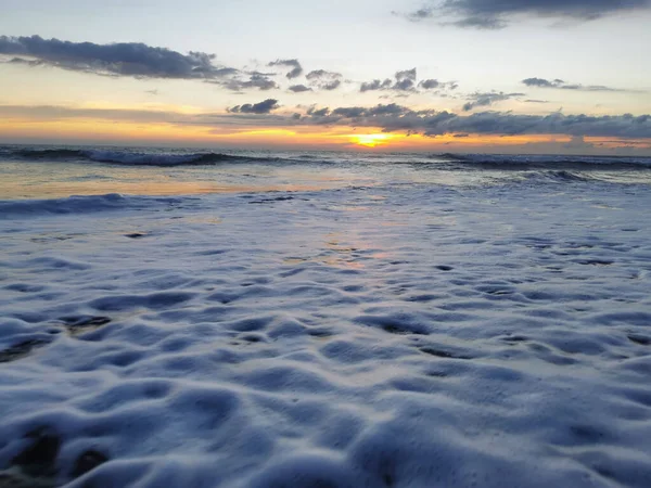 Una Hermosa Toma Puesta Sol Sobre Las Espumosas Olas Que —  Fotos de Stock