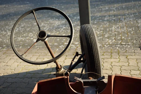 A steering wheel with three spokes of a self-made rotten tricycle at the car museum in Horstmar