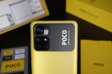 Canlı, sarı Xiaomi Poco M4 akıllı telefonun seçici odak noktası.