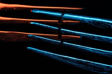 Karanlıkta iki çatalın yakın çekimi.