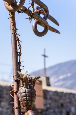 Dikey olarak dikenli teller ve eski bir el bombasıyla metal direğe yakın çekim. 1. Dünya Savaşı, Kuzey İtalya.