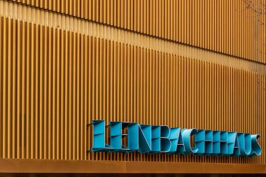 Münih, Almanya 'daki sarı çizgili duvarda Lenbachhaus mavi isim etiketi