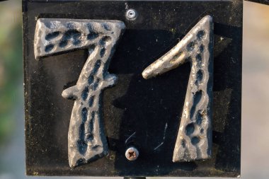 Açık havada gölgesi olan 71 numaralı demir levhanın yakın çekimi.