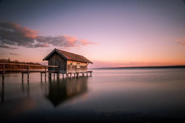 ドイツのバイエルン州の夕日の空に対するアメリカの湖の上のボートハウスの美しい景色 — ストック写真