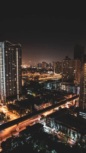 夜の光に照らされたバンコクの街の垂直ショット — ストック写真