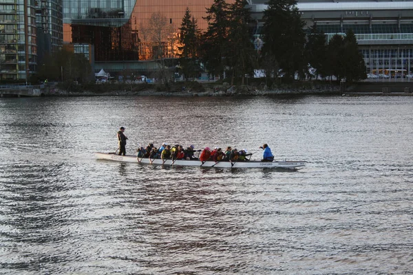 人々は日没の光の中で偽のクリークで長いカヌーを漕いでいます バンクーバー ブリティッシュコロンビア州 カナダ — ストック写真