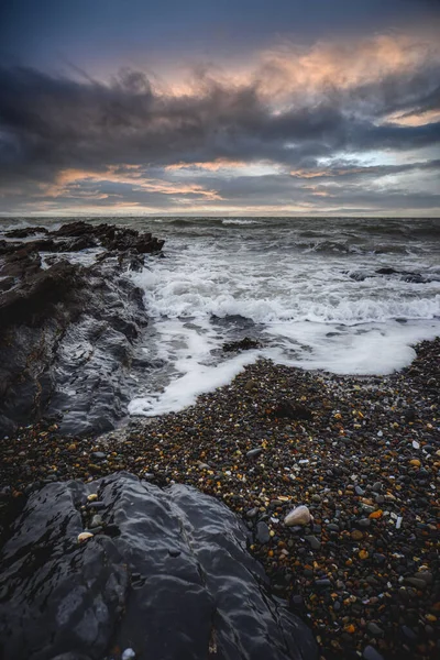 Disparo Vertical Olas Salpicando Sobre Rocas Atardecer —  Fotos de Stock