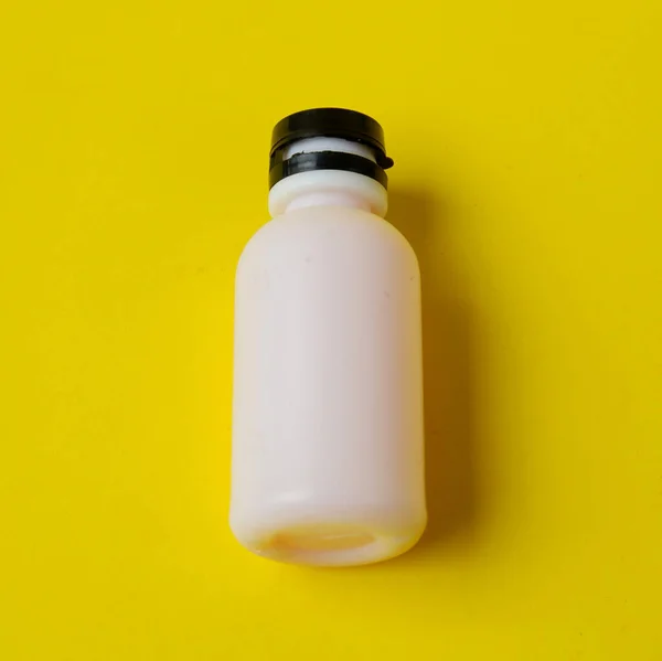 Egy Közeli Kép Egy Fehér Palackról Sárga Alapon — Stock Fotó