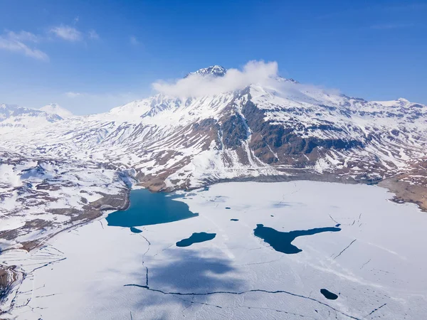 在阿尔卑斯山中被雪覆盖的冰封的湖面的空中拍摄 — 图库照片