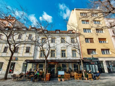Bratislava, Slovakya 'daki bir kafede güneşli bir günün keyfini çıkaran insanların uzak bir manzarası