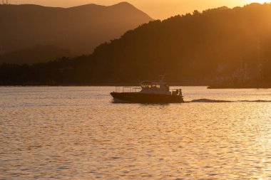 Portekiz, gün batımında Setubal limanında yelken açan bir teknenin manzarası.