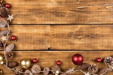 Kırmızı, altın topları ve çam kozalakları olan Noel ağacından bir çerçeve.