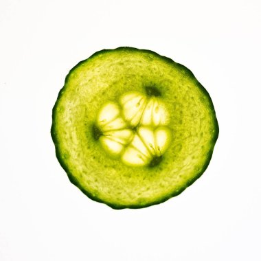 Beyaz arka planda izole edilmiş bir salatalık dilimine yakın plan.