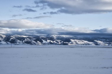 Bulutlu bir günde karlı bir dağ sırası