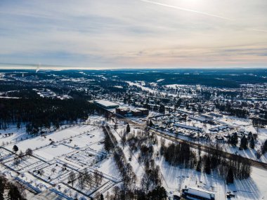 Yüksek ağaçlar, Skelleftea, İsveç çevresindeki karlı kır evlerinin geniş açılı görüntüsü.