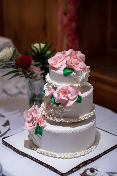 Vertikální Detailní Záběr Tradiční Třípodlažní Bílý Svatební Dort Růžovými Růžemi — Stock fotografie