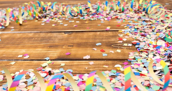 Ein Haufen Buntes Konfetti Und Luftschlangen Auf Einem Holztisch — Stockfoto