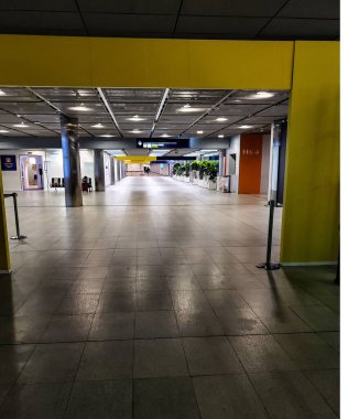 Sarı duvarları ve parlak ışıkları olan geniş bir salon.