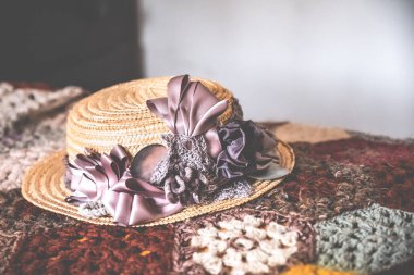 Leylak bir kurdelenin yakın plan çekimi yün yorganın üzerindeki hasır kayıkçı şapkasını budadı