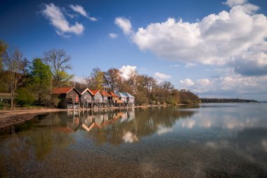 Almanya, Bavyera 'da kayıkhaneler ve Ammersee Gölü üzerindeki bulutlu gökyüzü