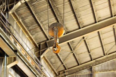 Tavandan sarkan demir bir kancanın seçici odak noktası.