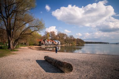 Almanya, Bavyera 'da kayıkhaneler ve Ammersee Gölü üzerindeki bulutlu gökyüzü