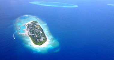 Güneşli bir günde kristal berrak mavi suyu olan güzel bir tropikal adanın hava manzarası.