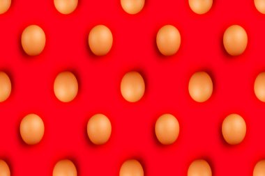 Kahverengi Paskalya yumurtaları canlı kırmızı arka planda izole edilmiş.