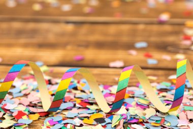 Bulanık ahşap arka planda bir sürü renkli konfeti ve flama