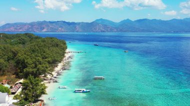 Sakin mavi bir deniz manzarası ve Endonezya 'da güneşli bir günde yemyeşil bir doğayla dolu bir sahil.