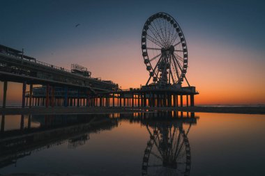 Hollanda, Lahey 'de günbatımında Scheveningen İskelesindeki dönme dolabın uzak bir görüntüsü