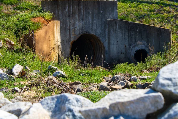 Άνοιγμα Σήραγγας Υπονόμων Που Περιβάλλεται Από Βράχους Και Πράσινα Φυτά — Φωτογραφία Αρχείου