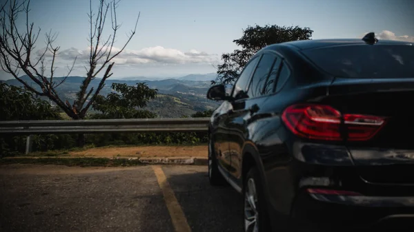Zadní Pohled Černé Auto Zaparkované Výhledem Hory Stromy — Stock fotografie