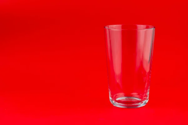 Kırmızı Zemin Üzerinde Izole Edilmiş Boş Bir Bardağa Yakın Çekim — Stok fotoğraf