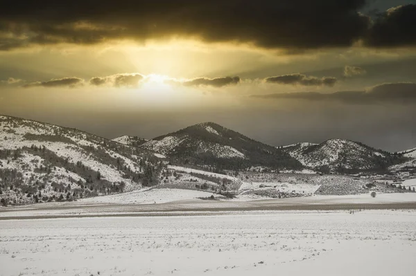 Malowniczy Widok Wzgórza Dolinę Pokrytą Śniegiem Pod Niebem Ciemnymi Chmurami — Zdjęcie stockowe
