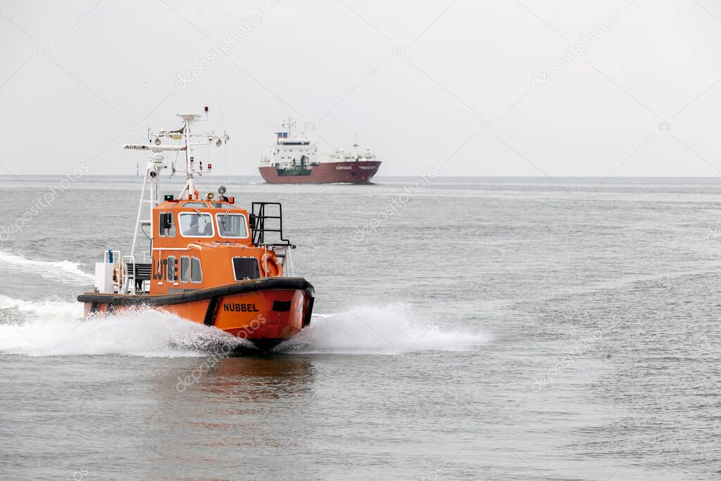 An orange pilot boat sailing on the Elbe River