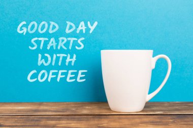 Mavi arka planda beyaz bir kahve fincanı üzerinde 